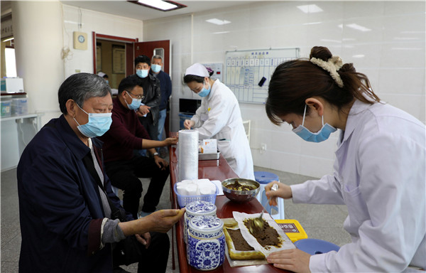 1650506593783517.jpg 为患者进行中药封包等治疗.JPG